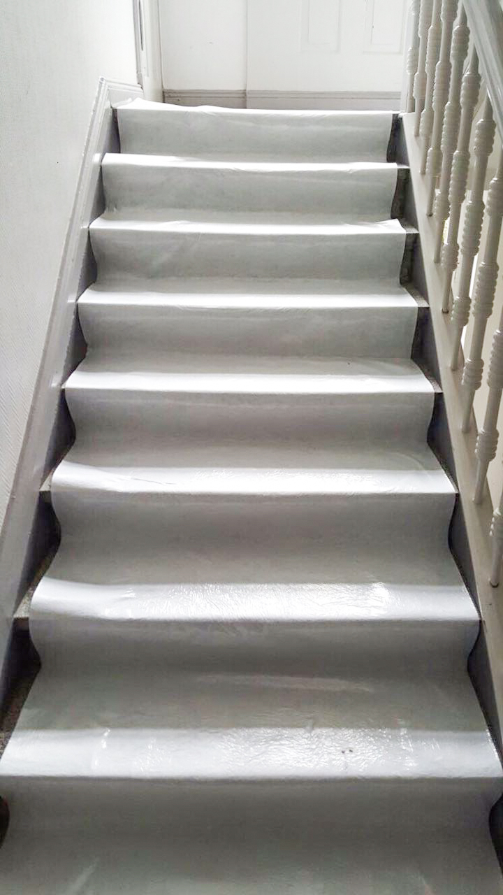 Weiße, selbstklebende Treppen-Schutzfolie als rutschhemmende Abdeckung auf Stufen im Innenbereich angebracht