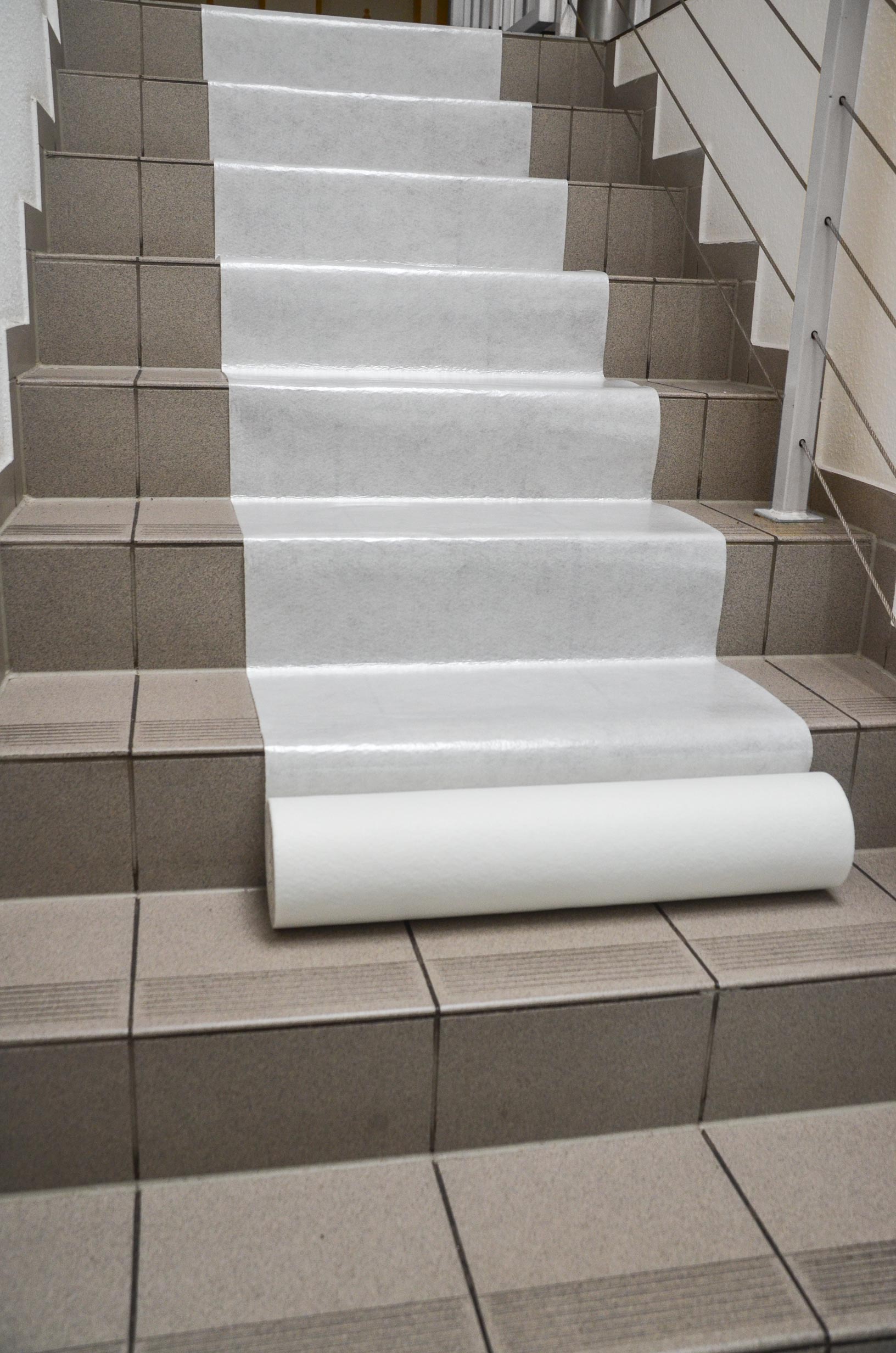 Weiße Schutzfolie als Abdeckung auf einer Fliesentreppe