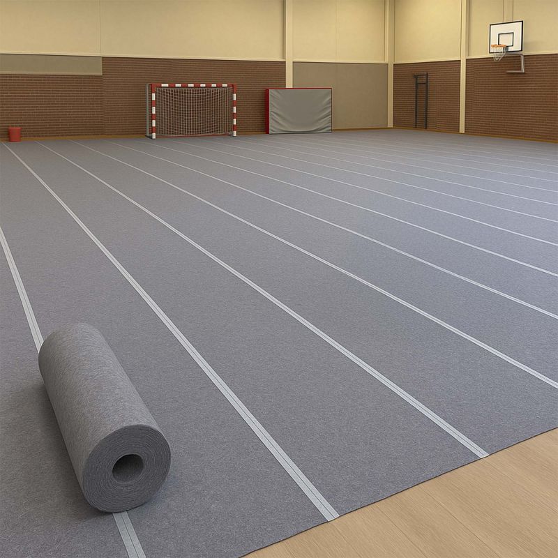 Grauer Hallenbodenschutz als Schutzbelag in einer Sporthalle mit Handballtor und Basketballkorb, teilweise noch auf Rolle