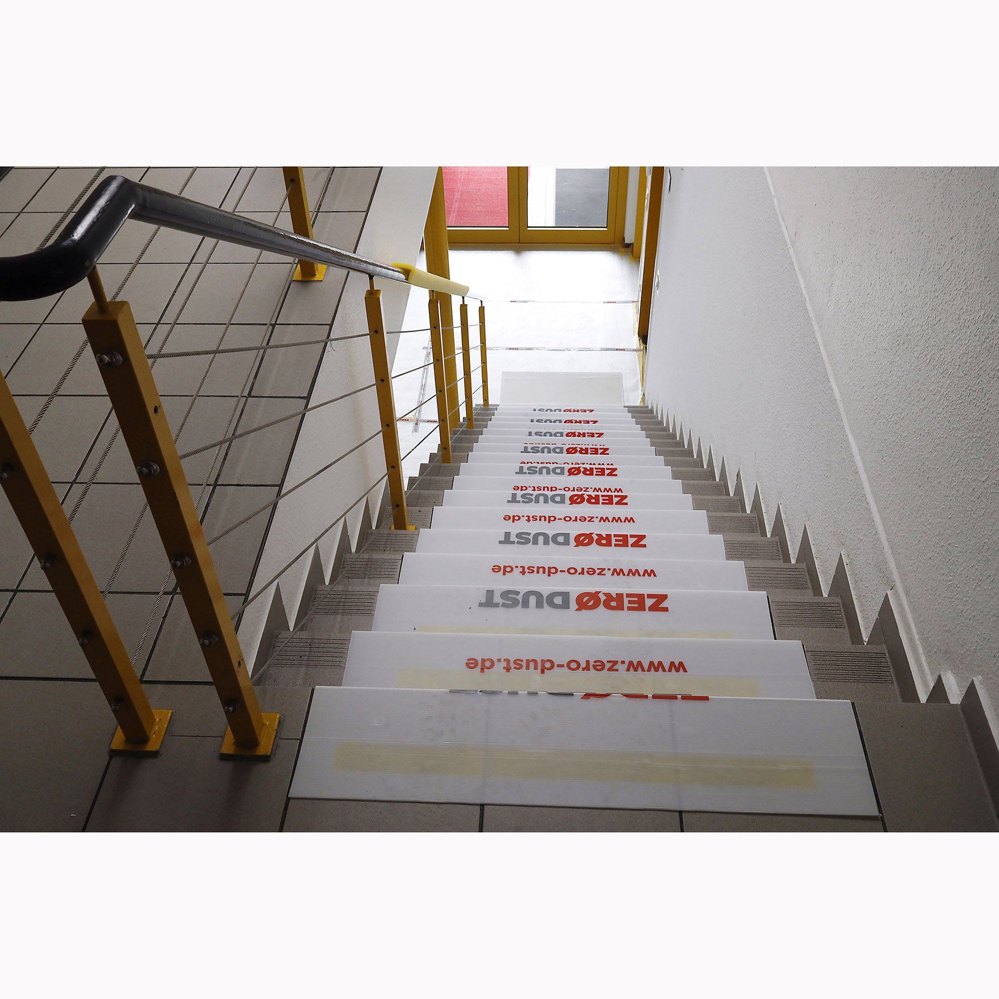 Innen-Treppenhaus mit rutschfesten Stufenaufklebern, bedruckt mit Schriftzug und Webadresse, für Werbe- oder Leitsysteme
