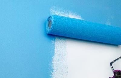 Wand wird mit blauer Farbe gestrichen, vorbereitet mit Collo