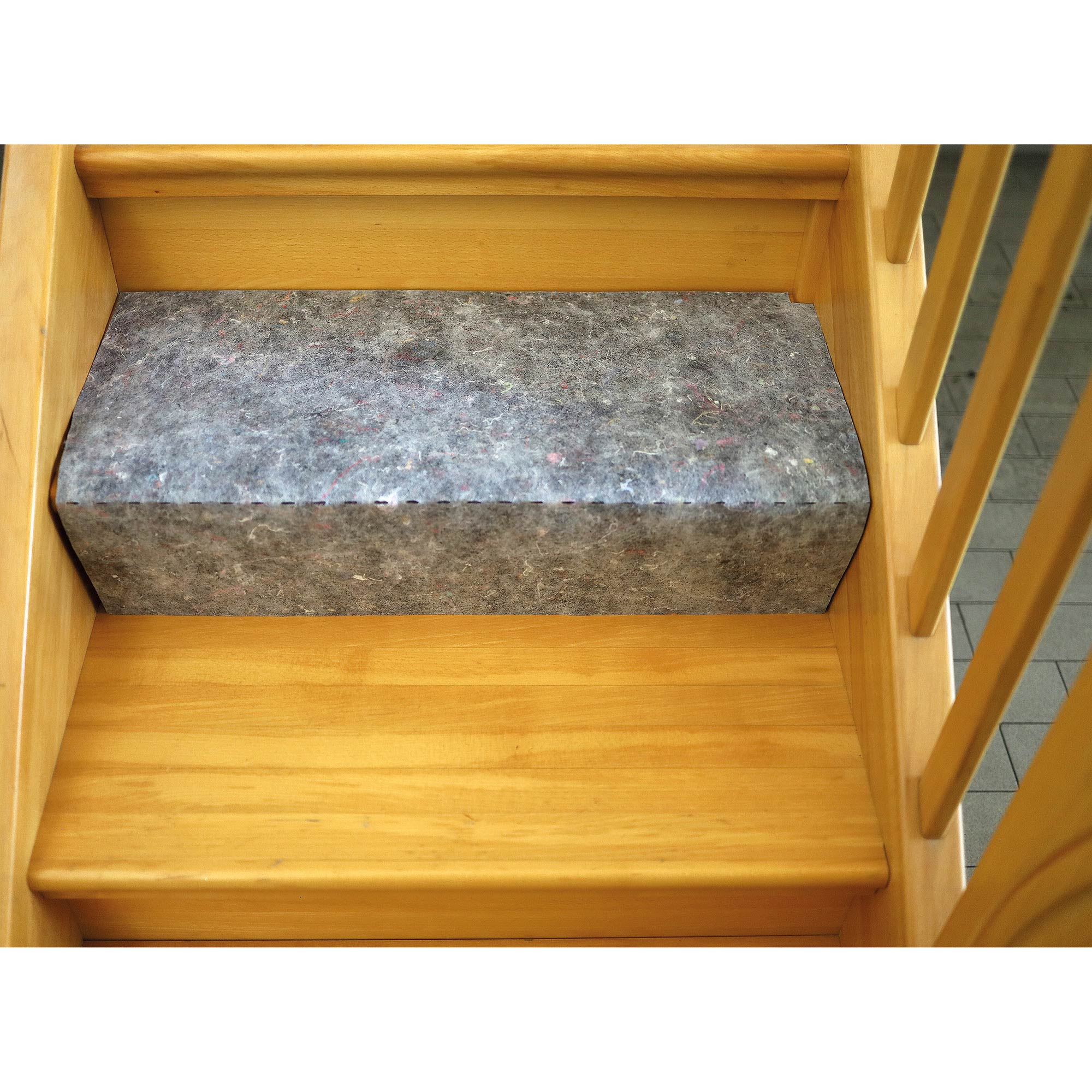 Graues Filz-Treppenschutzpolster auf einer Holztreppe zum Schutz vor Stößen und Kratzern