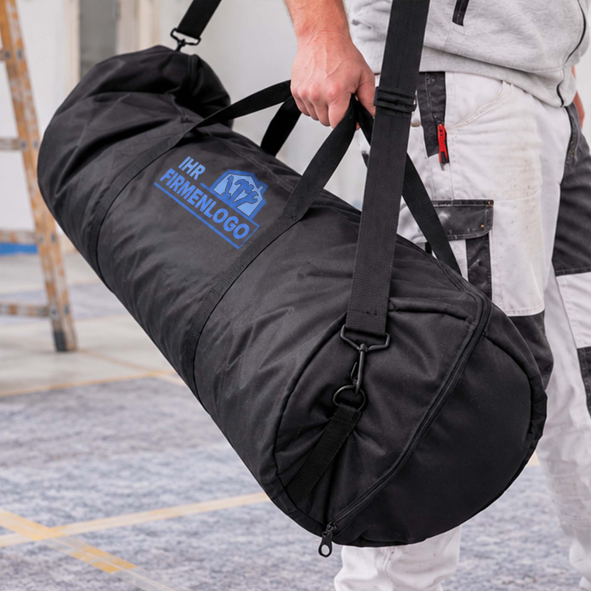 Maler trägt die Zero Dust MalerMuli Transporttasche für Vliesrollen bis 1,00 x 50 m und Zubehör, schwarze Tasche mit Ihrem Firmenlogo