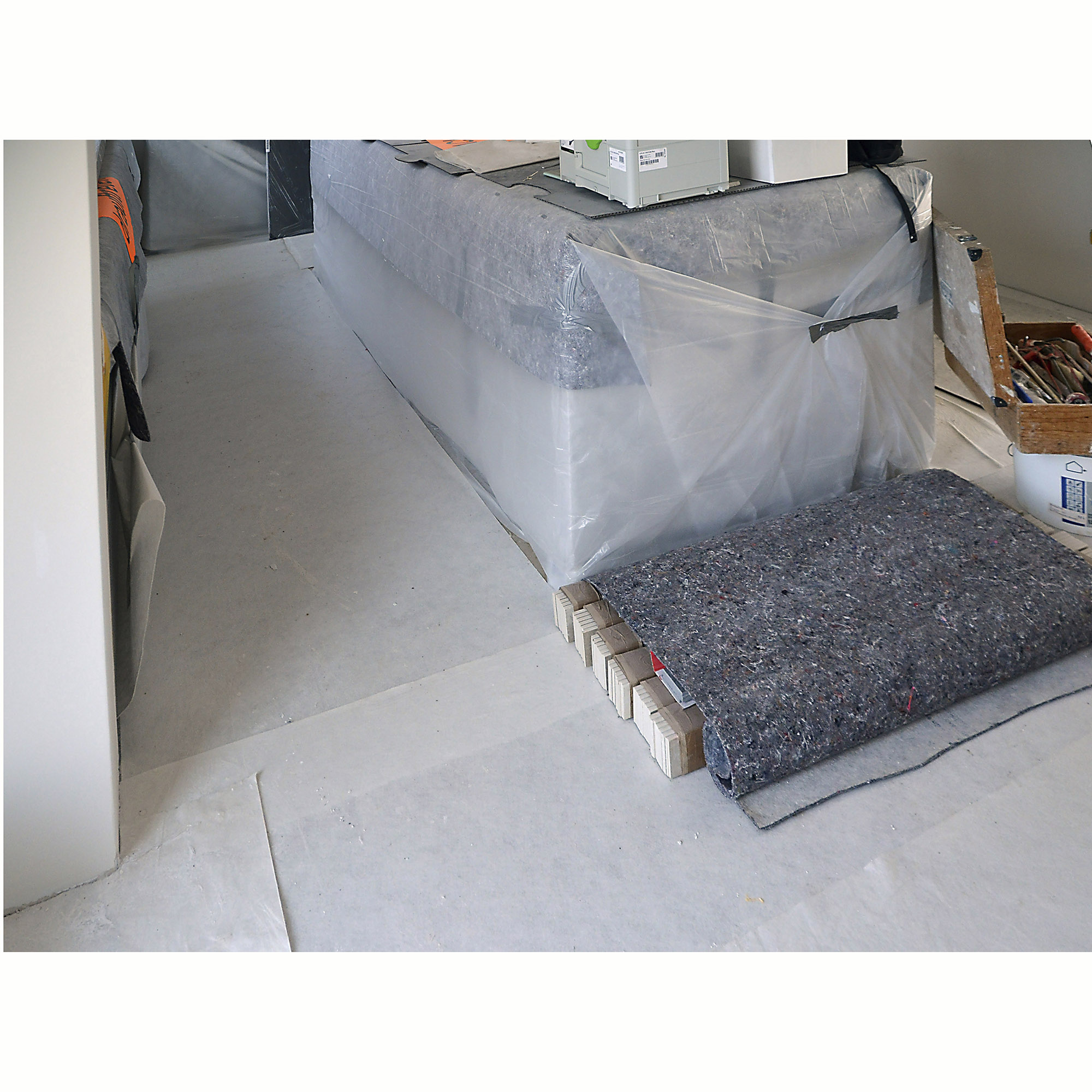 Raum während Renovierung mit ausgelegtem Bautenschutzvlies und Abdeckvlies zum Schutz des Bodens und der Möbel