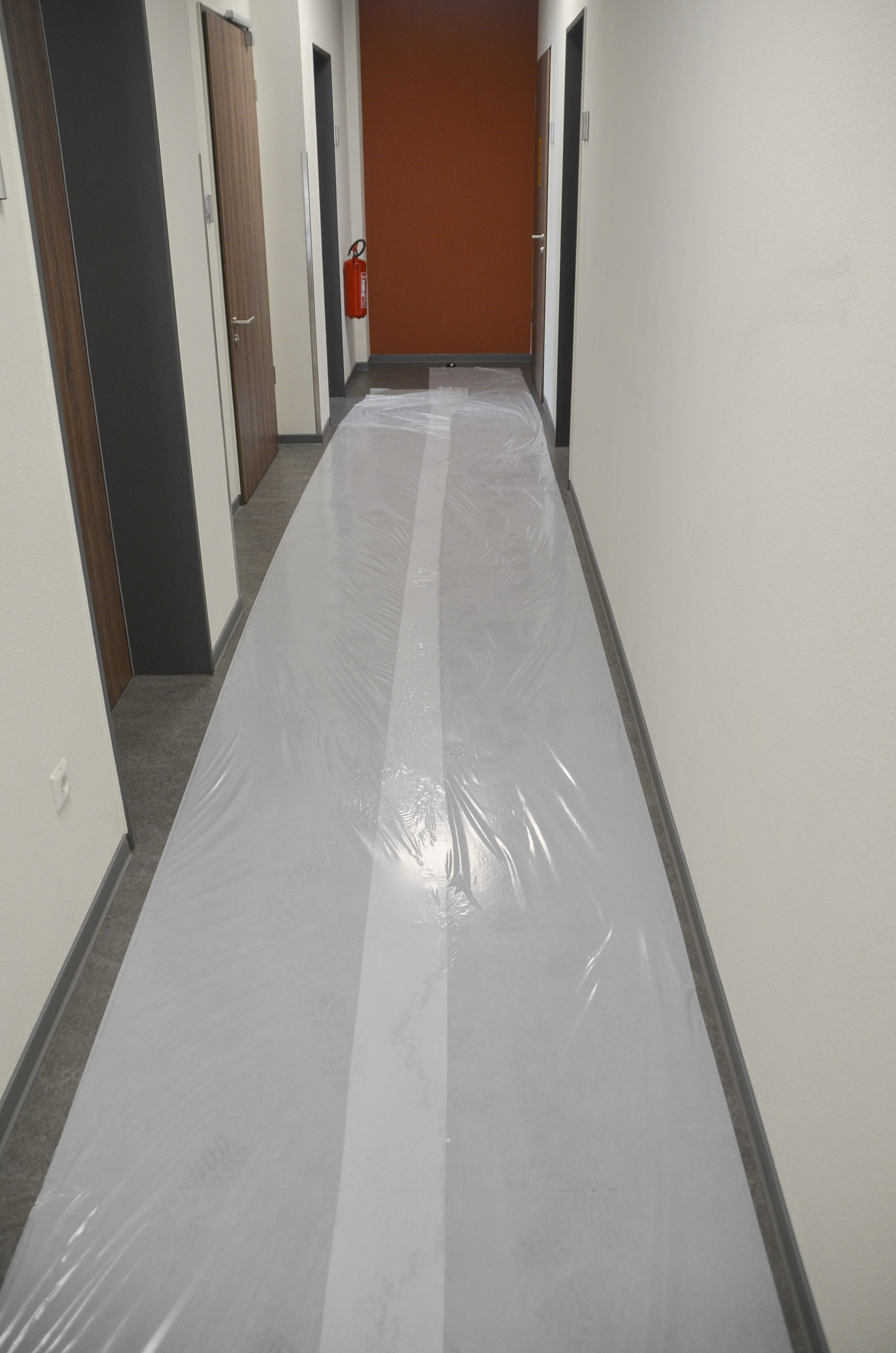 Langer Hausflur mit ausgelegter selbstklebender Schutzfolie zum Abdecken und Schützen des Bodens während Bau- oder Renovierungsarbeiten
